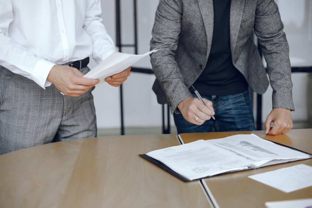 Dos personas firmando un documento